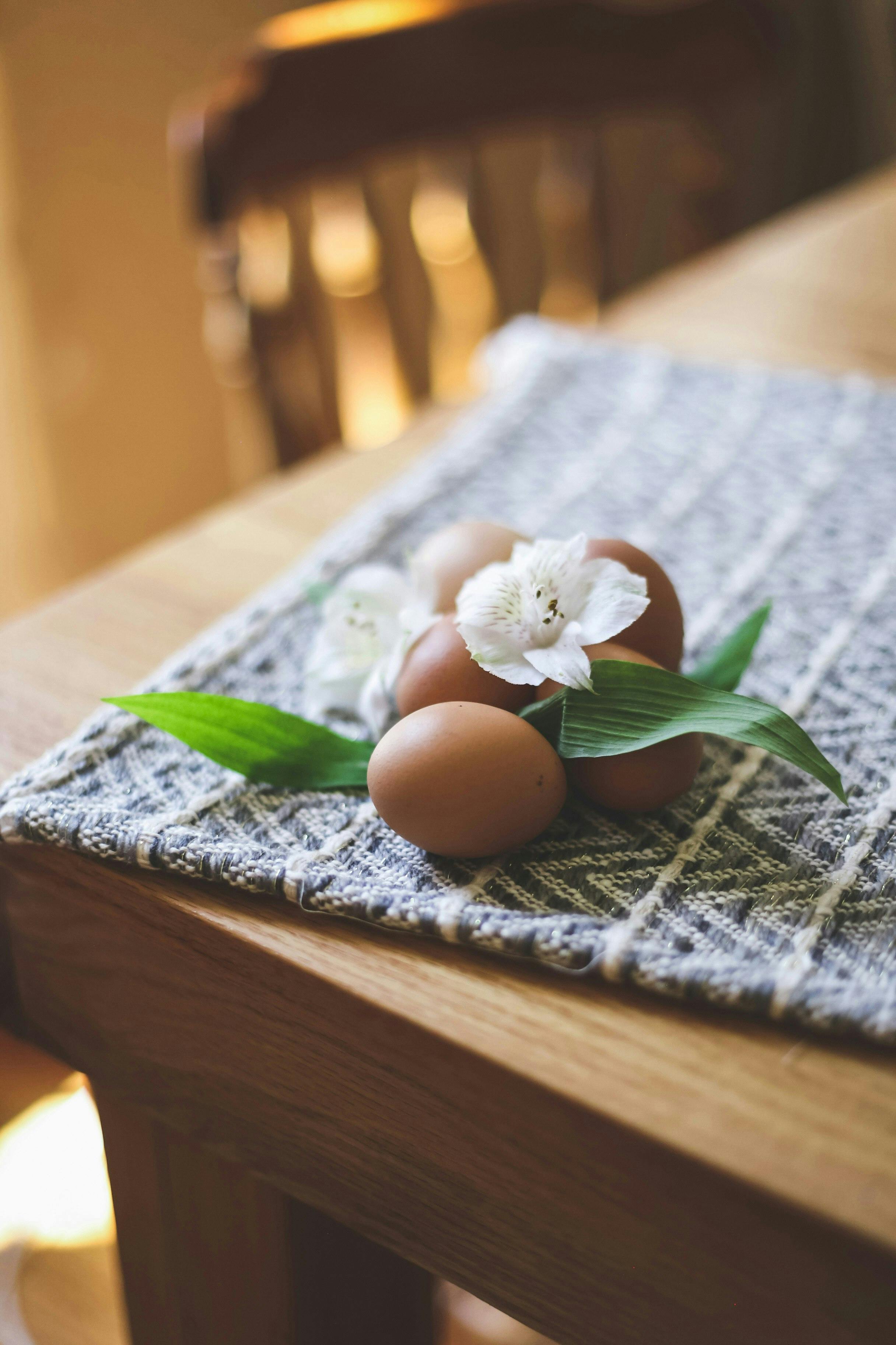 a wooden table topped with eggs and flowers