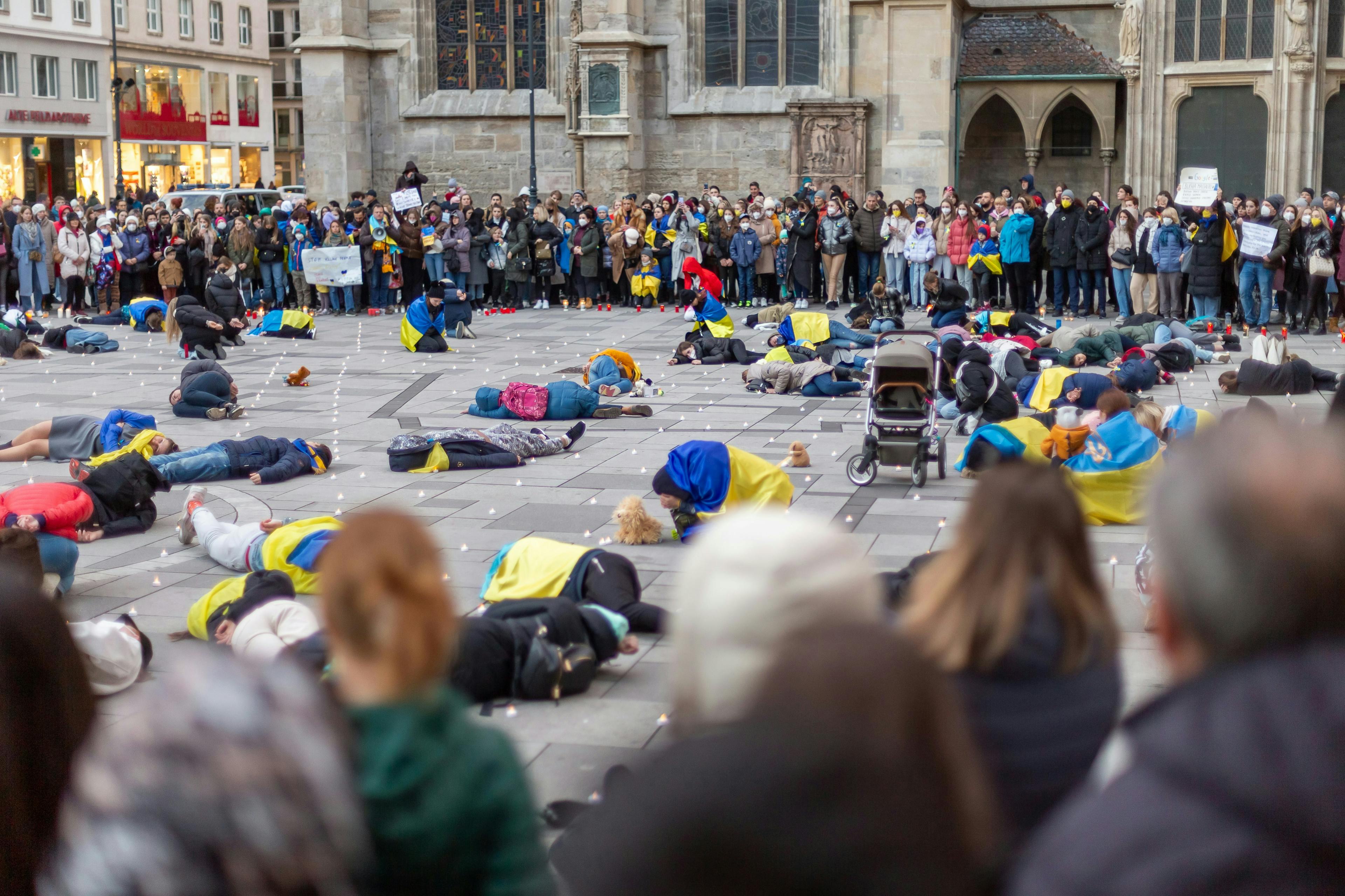 a crowd of people standing around a group of people laying on the ground