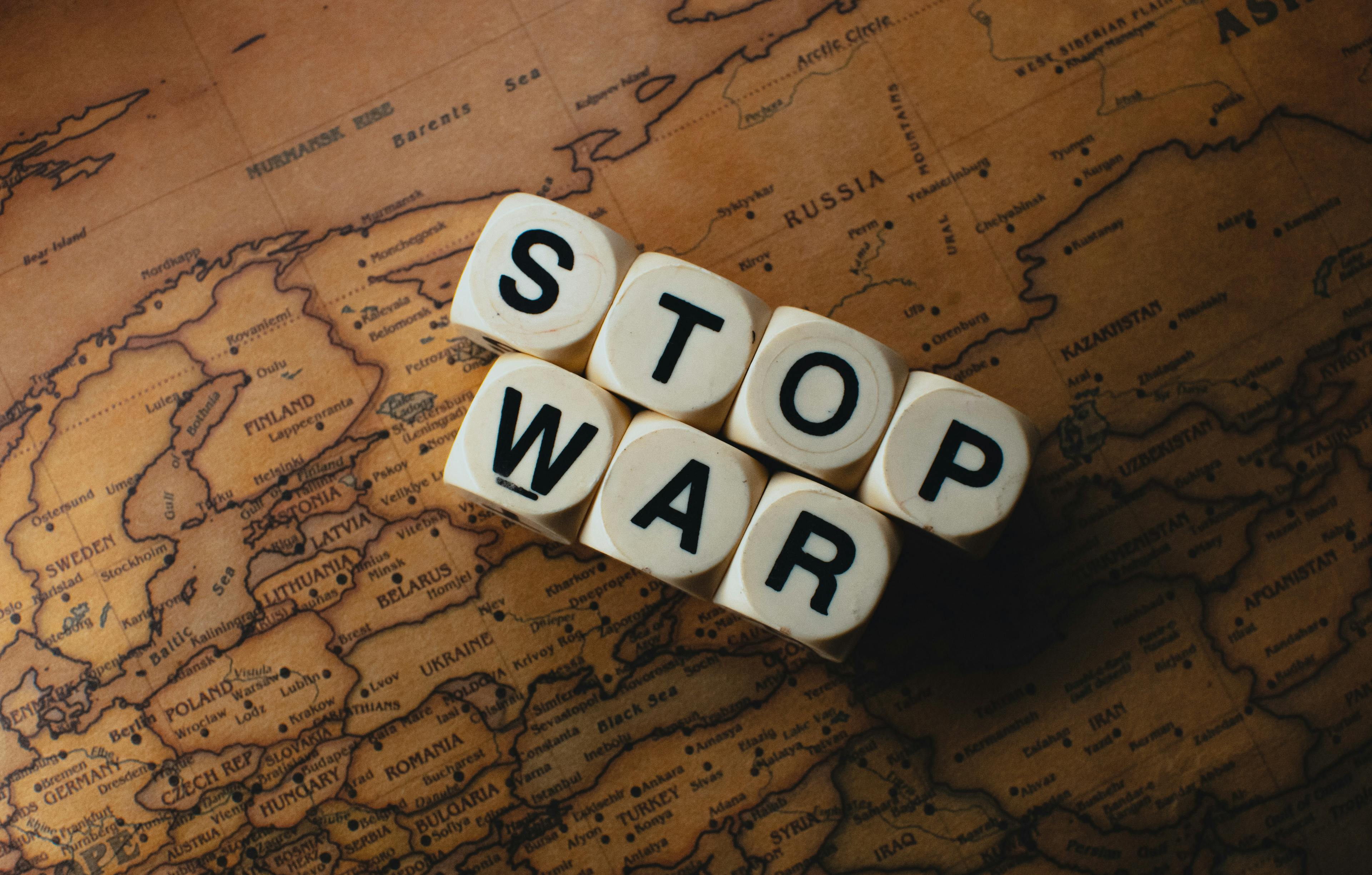a wooden block that says stop war on top of a map
