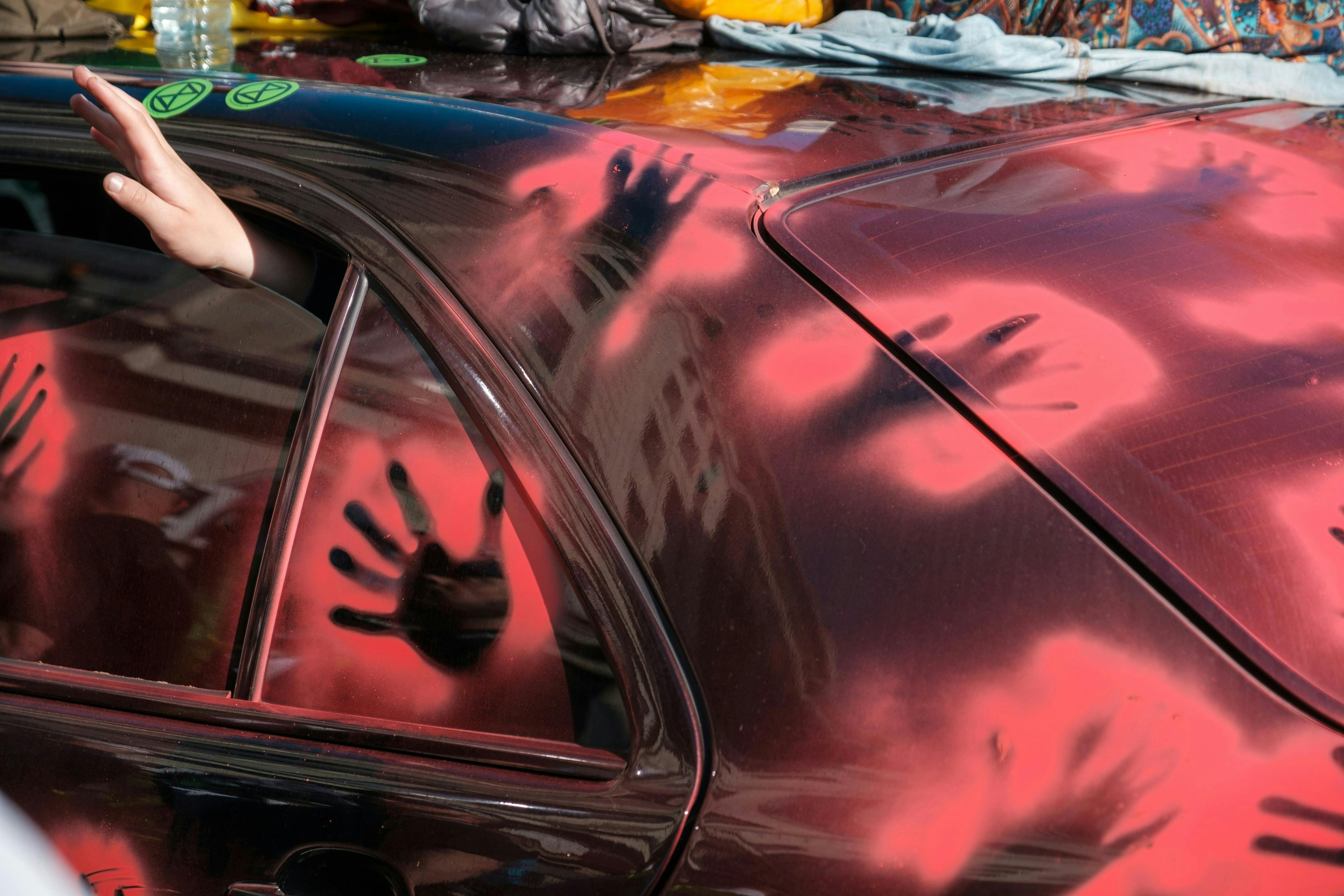 a hand print on the side of a red car