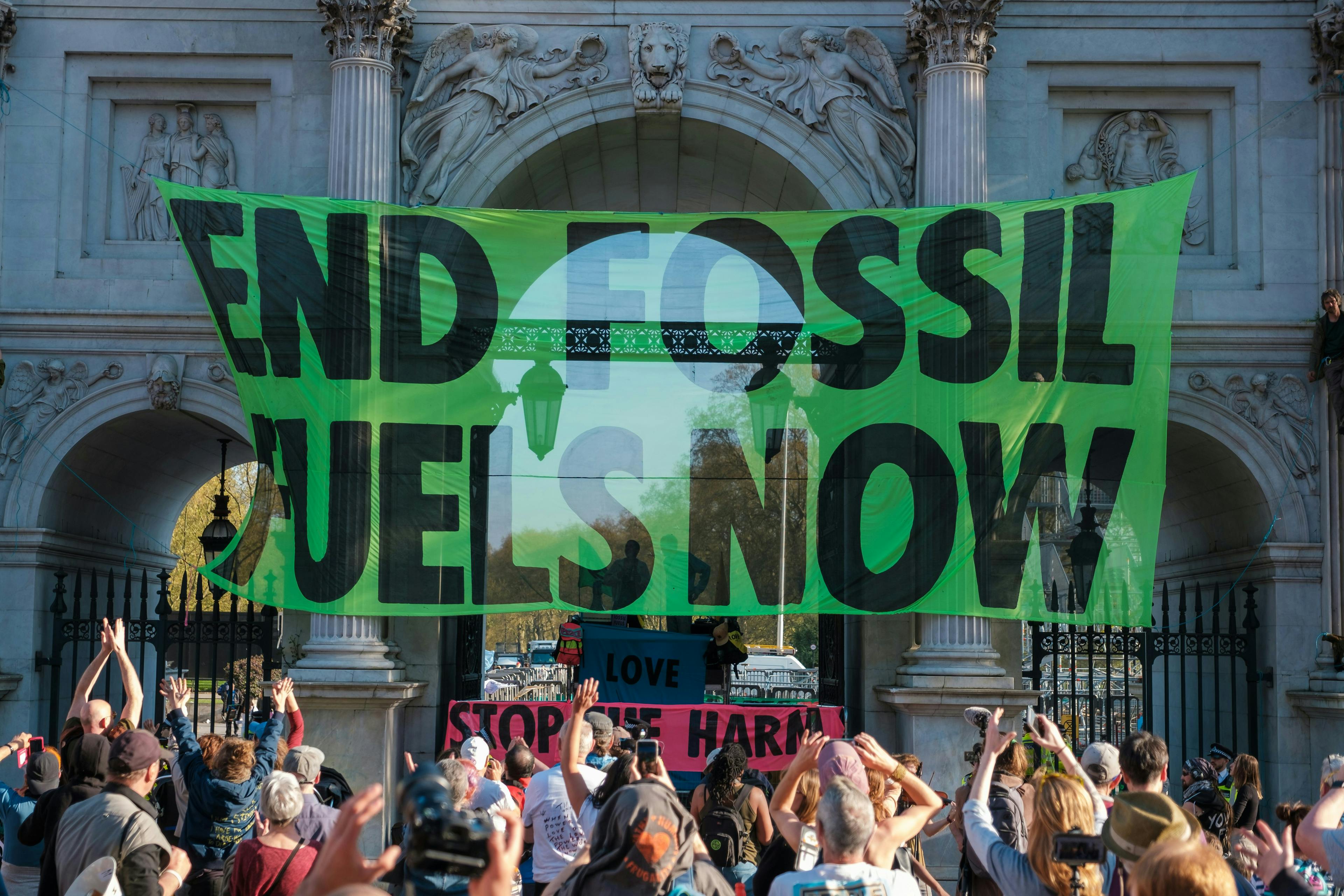 a group of people holding up a green sign