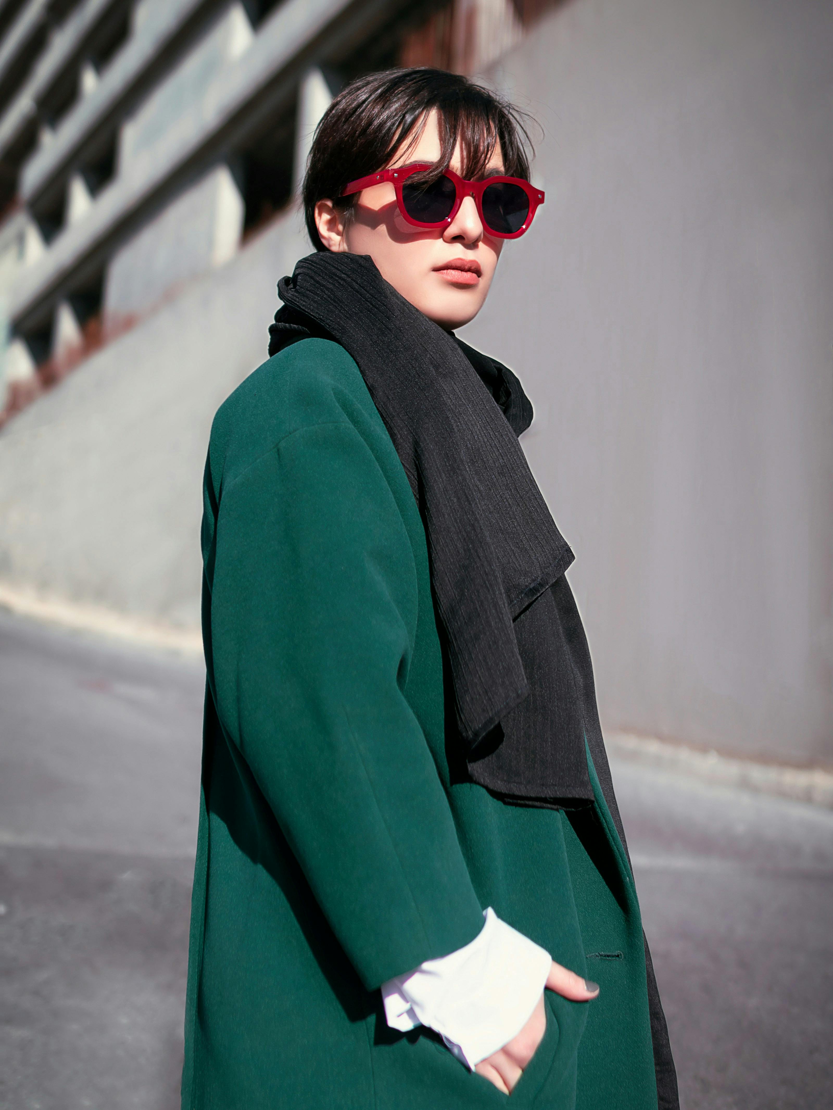 a person wearing sunglasses and a green coat